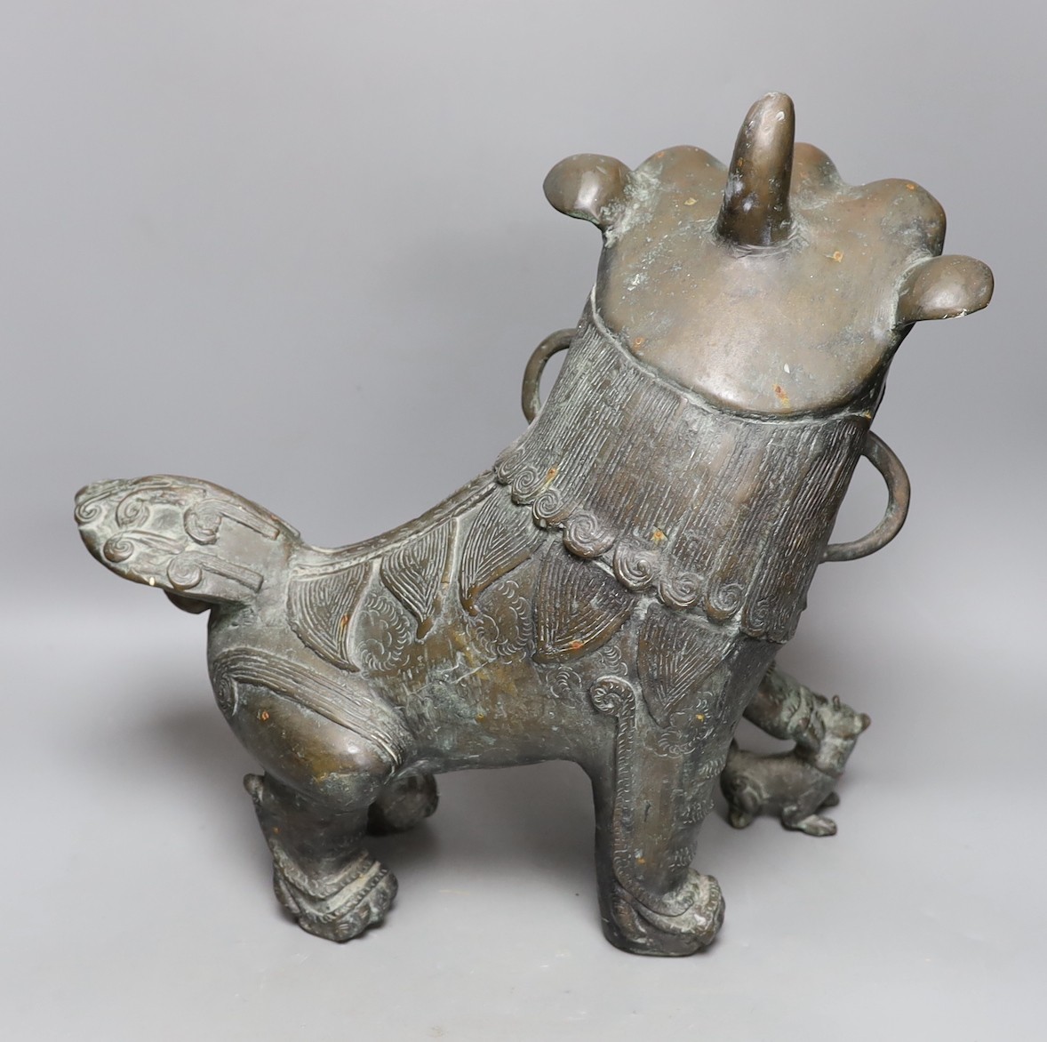 A large spSouth East Asian cast bronze metal floor-standing temple lion with iron spurs, 40cm tall